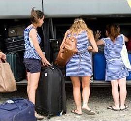 Turistas metiendo su equipaje en el autobús del aeropuerto.