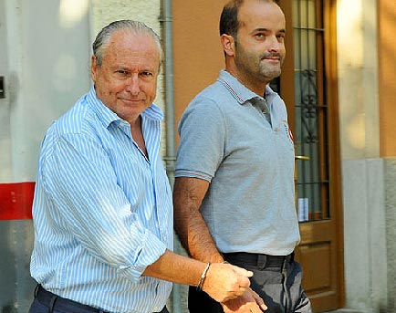 Dos d elos detenidos, esposados por la muñeca derecha.