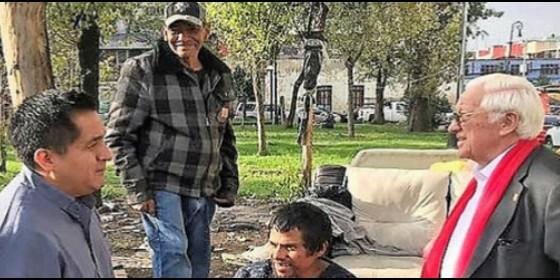 El padre Benito (i), párroco del Templo, conversa con el padre Ángel (d) y dos indigentes