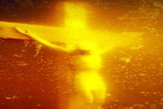 Destruyen a martillazos una foto de un crucifijo en un bote de orina