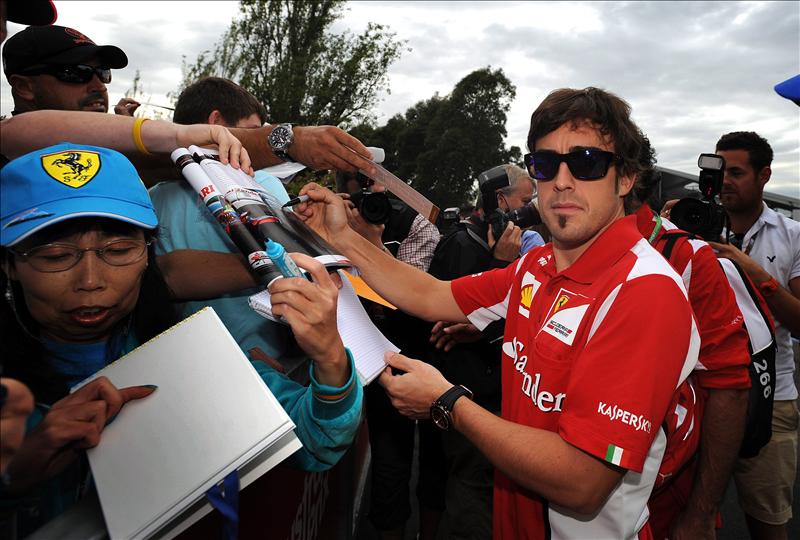 Fernando Alonso firmando aut&oacute;grafos