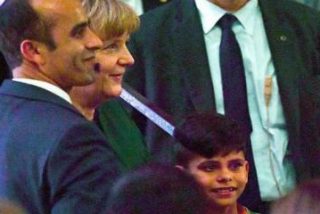 El momento en que un "agradecido" ni&ntilde;o afgano le quiere coger la mano a Angela Merkel