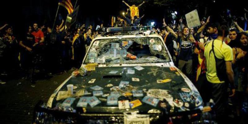 Manifestantes independentistas destrozan veh&iacute;culos de la Guardia Civil y roban armas ante la mirada impotente de los Mossos