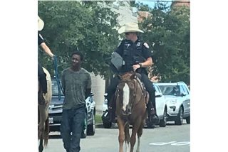 La foto de dos polic&iacute;as a caballo en Texas llevando a un hombre negro esposado y con una cuerda