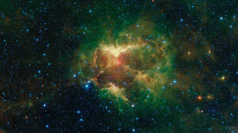 Esta nube de polvo espacial con forma de "calabaza" incandescente es captada por la NASA
