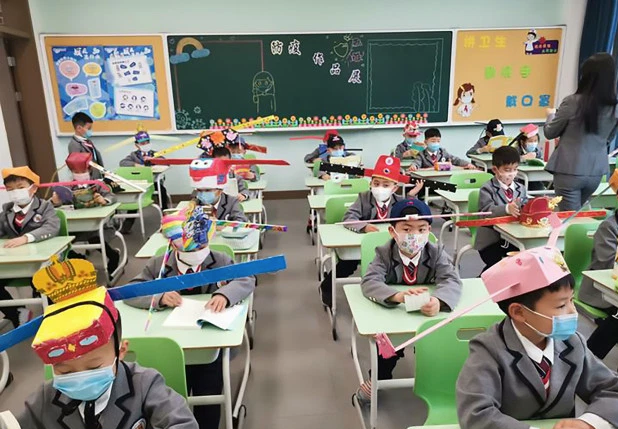 Sombreros de helic&oacute;pteros o cub&iacute;culos de papel: La f&oacute;rmula china para mantener el distanciamiento en las aulas