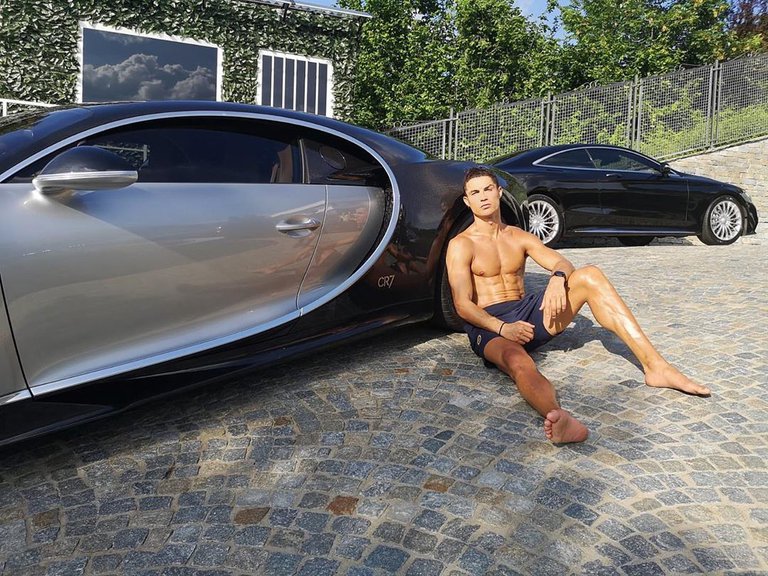 Cristiano Ronaldo tomando el sol sobre su deportivo Bugatti de 8 millones