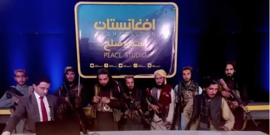 El tenso momento en que un periodista afgano transmite en TV rodeado por talibanes armados