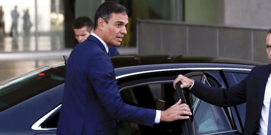 Pedro S&aacute;nchez, saliendo de su coche oficial y escoltado por la polic&iacute;a.