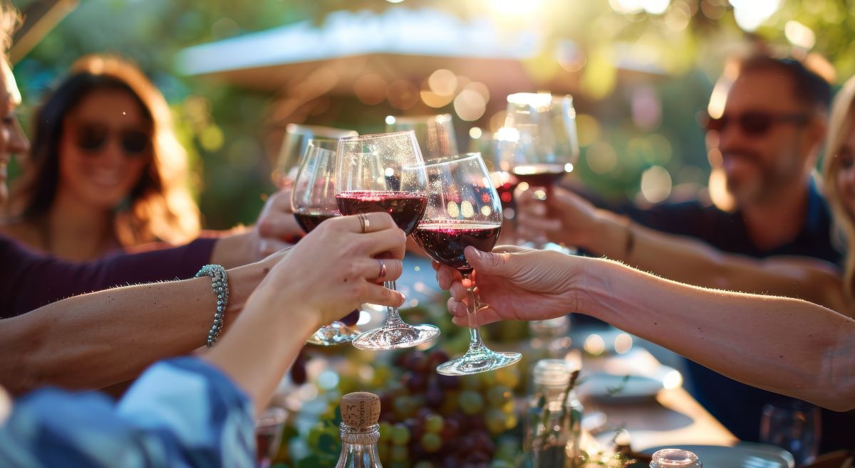 Grupo de amigos celebrando a lo grande y brindando con vino.