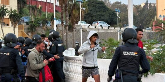 Policía e invasores marroquíes en Ceuta.